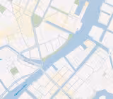 Et digitalt kort, der viser en flod, der løber gennem en by, med forskellige broer og gader mærket på dansk. Området omfatter bygninger, parker og vandveje, der illustrerer en del af en by med detaljerede planlægningslinjer.