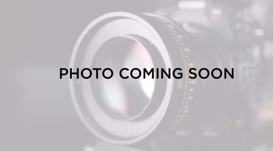 Et pladsholderbillede med et sløret kamera i baggrunden og teksten "Photo Coming Soon" overlejret i midten.